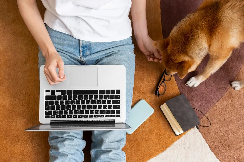 Tutor no notebook com o cachorro ao lado